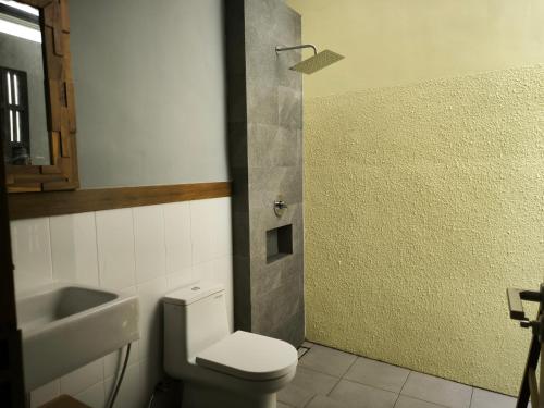 a bathroom with a toilet and a sink at The Umbu Stay Banyuwangi in Banyuwangi