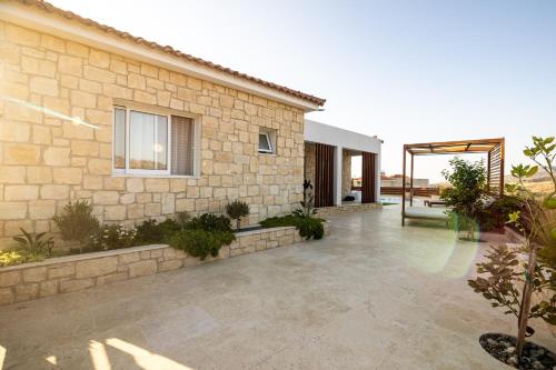 a stone house with a courtyard with a patio at Villa Flam in Kholi
