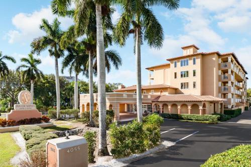 a building with palm trees in front of a street at Inn of Naples, Tapestry Collection by Hilton in Naples