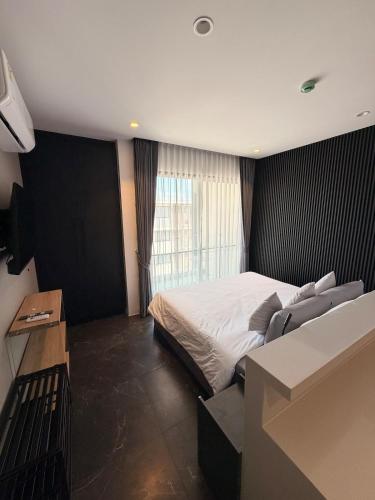 a bedroom with a bed and a large window at Utopia Dream in Rawai Beach