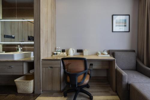 a room with a desk with a chair and a sink at Atour Hotel Jinan High-tech Wanda Plaza Tiancheng Road in Jinan
