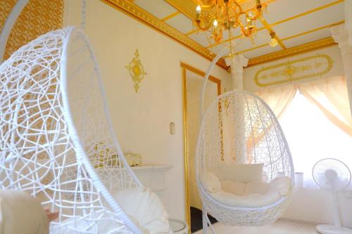a room with two hanging chairs and a chandelier at はじまりの宿 ディール in Tsumagoi