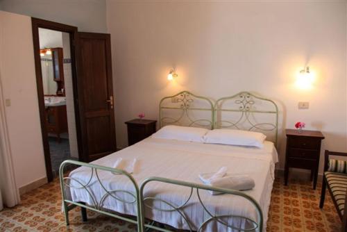 a bedroom with a bed and two chairs in a room at Il Delfino in Santa Marina Salina