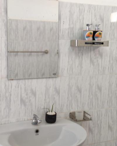 un baño con lavabo y espejo en E-Beach Resort, en Negombo