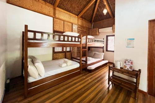 two bunk beds in a room with a wooden floor at Torres Farm Resort powered by Cocotel in Naic
