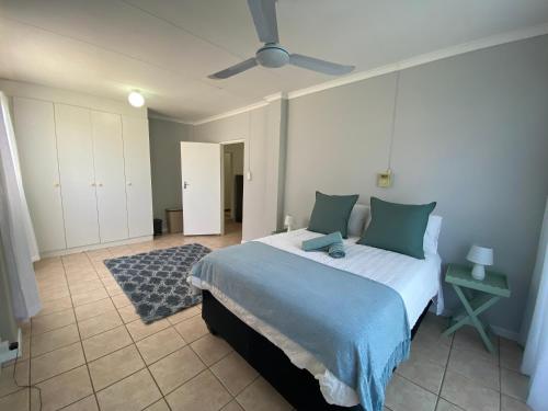 a bedroom with a bed and a ceiling fan at Beach Cresent Cottage in Port Alfred