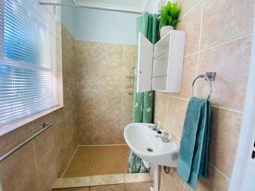 a bathroom with a sink and a mirror at Beach Cresent Cottage in Port Alfred