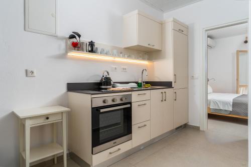 a kitchen with white cabinets and a stove top oven at Stay in Falassarna Rooms & Apartments in Falasarna