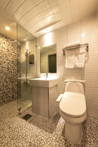 a bathroom with a toilet and a sink and a shower at 에이치에비뉴 호텔 남춘천점 in Chuncheon