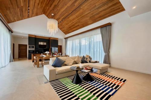 a living room with a couch and a table at Bougainvillea Luxury Pool Villas in Ban Pak Lak