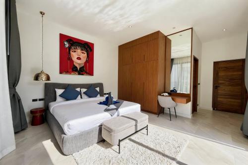 a bedroom with a bed and a painting on the wall at Bougainvillea Luxury Pool Villas in Ban Pak Lak