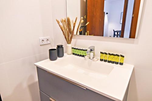 a bathroom with a white sink and a mirror at Contemporary Chic with Terrace & Balcony in Madrid