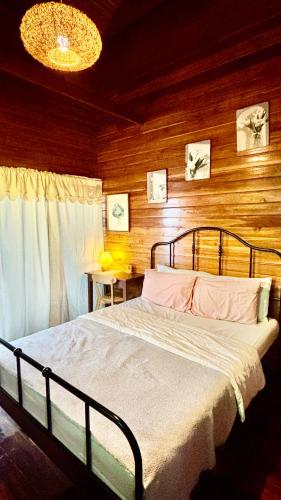 a bedroom with a bed and a wooden wall at Rang Robin Farmstay for 4 with pool in Ban Wang Muang