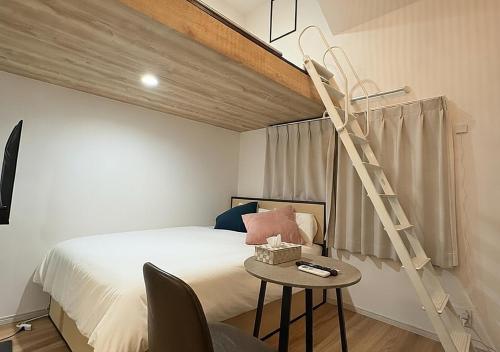 a bedroom with a bed and a ladder next to a bed at Shinjuku Topshot Hotel in Tokyo