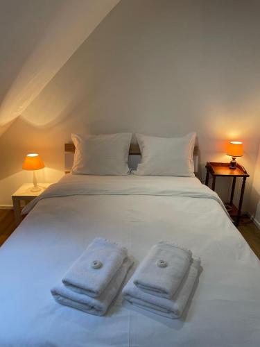 a bedroom with a white bed with two towels on it at Modern Appartement in Courroux