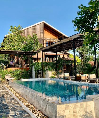 a swimming pool in front of a building at Rang Robin Farmstay for 4 with pool in Ban Wang Muang