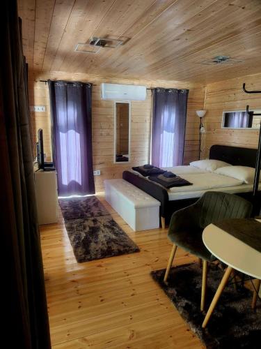 a living room with a bed and a couch at Woodbox Noszvaj in Noszvaj