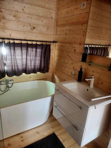a bathroom with a white tub and a sink at Woodbox Noszvaj in Noszvaj