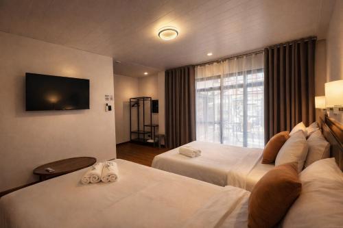 a hotel room with two beds and a television at Balai de Biday 4 Pax Suite with Breakfast Option in Mameltac