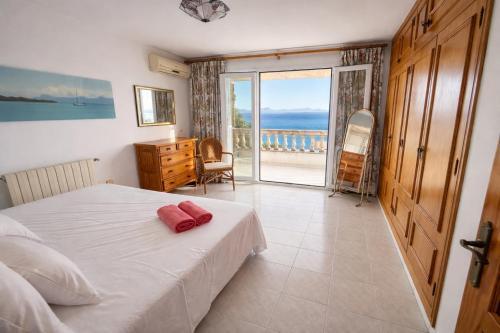 a bedroom with a bed and a view of the ocean at Auba Mar - Alcudia Sea View in Alcudia