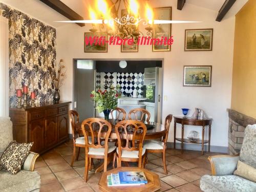 a dining room with a table and chairs at Les Fleurs De Lys, Villa Chic L'enclos Des Lys, Proche de la Mer in Saint-Georges-dʼOléron