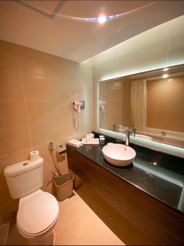 a bathroom with a white toilet and a sink at Batam View Beach Resort in Nongsa