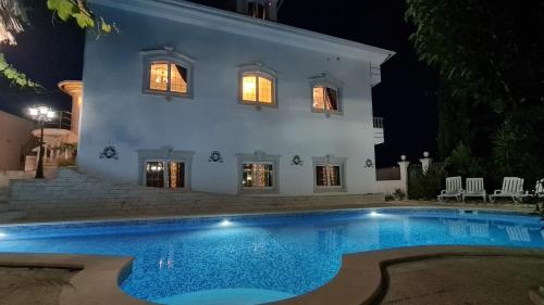 a house with a swimming pool at night at Silver Coast Pool & Resort Villas in Arnal