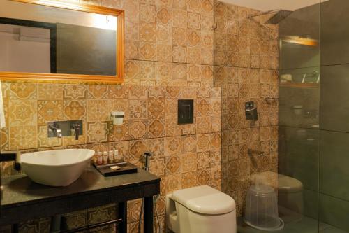 a bathroom with a sink and a toilet and a mirror at Willow Resorts Wayanad in Ambalavayal