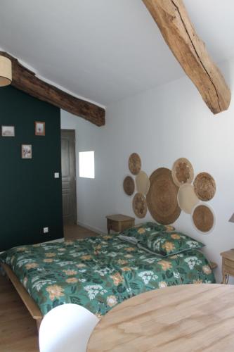 a bedroom with a bed with a green comforter at Chambre Au clos des auges in Saint-Saturnin-du-Bois