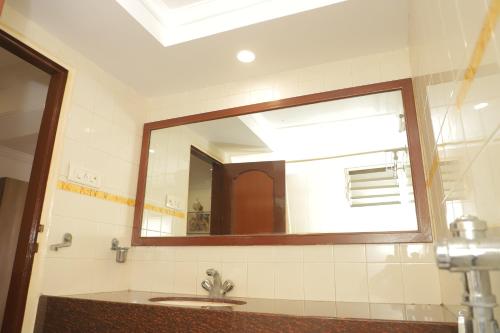 a bathroom with a sink and a large mirror at HOTEL GALAXY SURAT in Surat