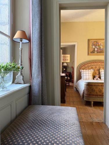 Un dormitorio con una cama y una mesa y una ventana. en L Epernon, en Alençon