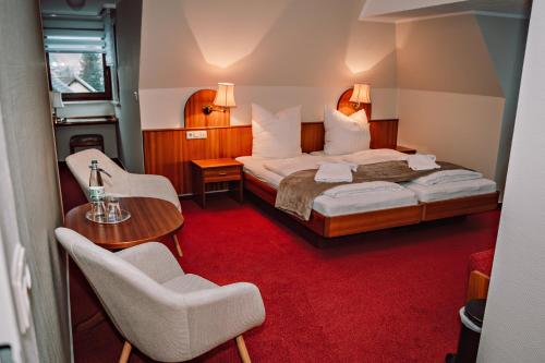 a hotel room with a bed and a table and chairs at Hotel Morgensonne in Augustusburg