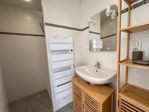 a bathroom with a sink and a mirror at Murat - La petite maison Murataise in Murat
