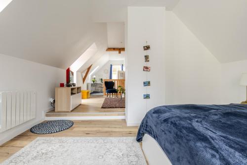a bedroom with white walls and a bed in a room at Duplex City Hag in Haguenau