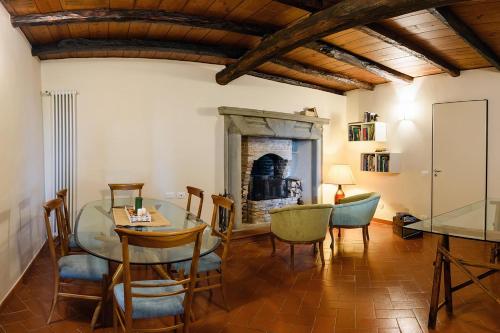 une salle à manger avec une table, des chaises et une cheminée dans l'établissement Tenuta Ronco Regio, à San Fermo della Battaglia