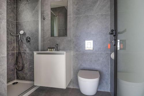 a bathroom with a toilet and a sink and a shower at Piliou Premium Apartments in Limassol