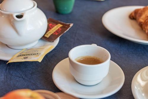 a cup of coffee on a table with plates of food at Albergo Residenziale Gli Ontani in Cala Liberotto