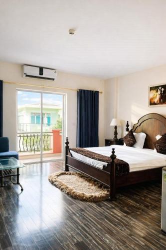 a bedroom with a large bed and a balcony at Hoàng Lê Hotel in Ho Chi Minh City
