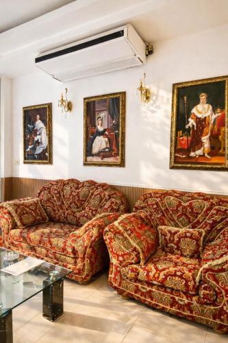 a living room with two couches and paintings on the wall at Hoàng Lê Hotel in Ho Chi Minh City