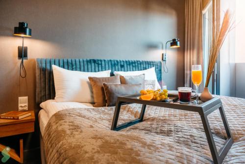 a bed with a tray of food and drinks on it at HANZA Pionier 2 pokoje i balkon SPA & Pool Parking by stayly in Szczecin