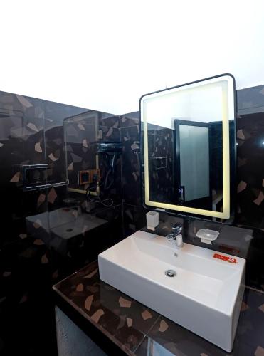 a bathroom with a white sink and a mirror at Zephyra Ella in Ella