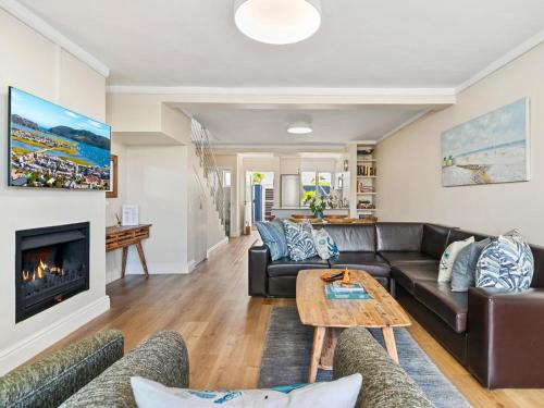 a living room with a couch and a fireplace at KnysnaQuays 4 in Knysna
