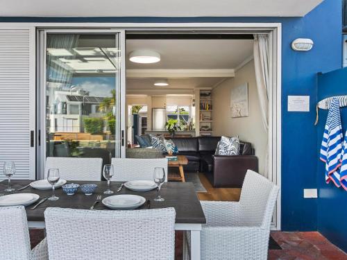 a dining room with a table and white chairs at KnysnaQuays 4 in Knysna