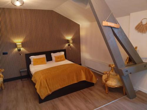 a bedroom with a large bed with yellow pillows at hotel de kaaipoort in Aardenburg