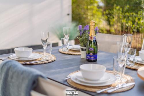 a table with a bottle of wine and plates and glasses at Thyline One - new spacious apartment for 8 persons in Nieuwpoort