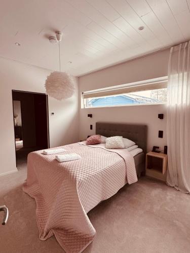 a bedroom with a bed with a pink blanket at Forest Dream House in Naantali