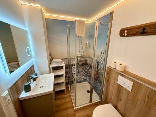 a bathroom with a shower and a toilet and a sink at Landhotel Esen in Neuharlingersiel