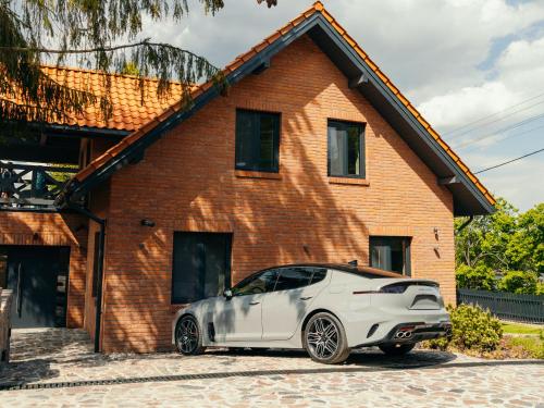 a white car parked in front of a brick house at Villa D'Jora in Mikołajki