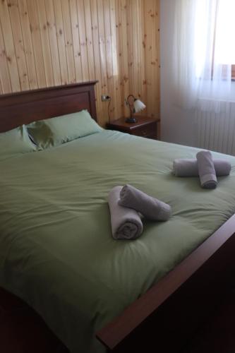 a bed with two towels on top of it at Al Roser in Forno di Zoldo