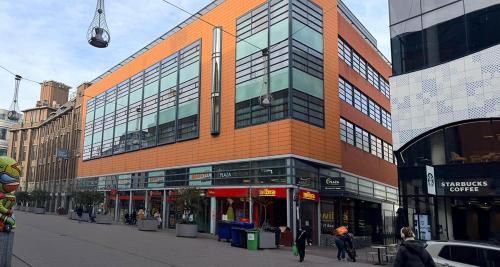 a building on a street with people walking in front of it at PLAZA Premium Den Haag City Center in The Hague